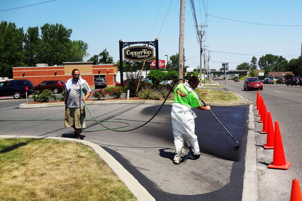 Workers sealing pavement